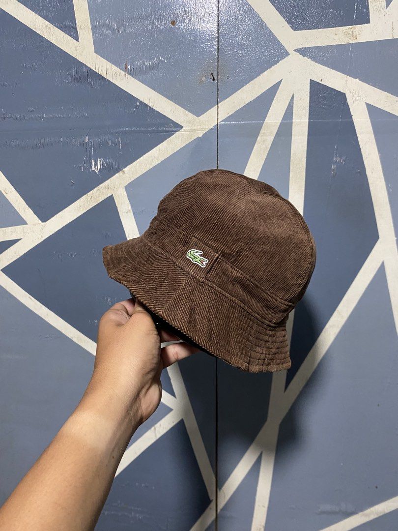 Lacoste Brown Corduroy Bucket Hat (Category: Caps & Hats) located in Polomolok. Submitted by marrssz (Listing ID 1470744276, Image 3). Description: - Brand: Lacoste - Material: Textured brown corduroy fabric - Design: Classic bucket hat with sloping brim and dark inner lining - Detail: Iconic embroidered crocodile logo patch on the front - Style: Perfect everyday streetwear accessory for casual outfits -MEDIUM TO LARGE HEAD.