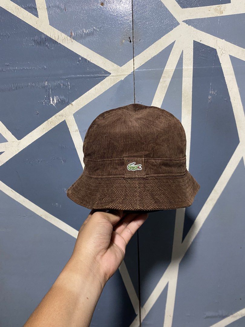 Lacoste Brown Corduroy Bucket Hat (Category: Caps & Hats) located in Polomolok. Submitted by marrssz (Listing ID 1470744276, Image 2). Description: - Brand: Lacoste - Material: Textured brown corduroy fabric - Design: Classic bucket hat with sloping brim and dark inner lining - Detail: Iconic embroidered crocodile logo patch on the front - Style: Perfect everyday streetwear accessory for casual outfits -MEDIUM TO LARGE HEAD.