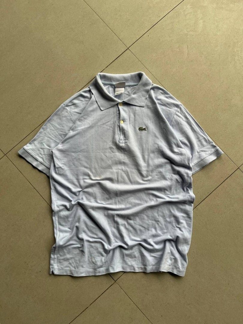 Lacoste Light Blue Polo Shirt Size 7 (Category: Tshirts & Polo Shirts ) located in Santa Cruz. Submitted by remsonnnc (Listing ID 1470814389, Image 1). Description: - Brand: Lacoste - Color: Light blue - Size: 7 - Material: 100% cotton pique fabric (Designed in France, made in Peru) - Details: Classic 2-button placket with mother-of-pearl buttons, standard collar, short sleeves - Logo: Iconic embroidered green crocodile on the chest - Condition: 