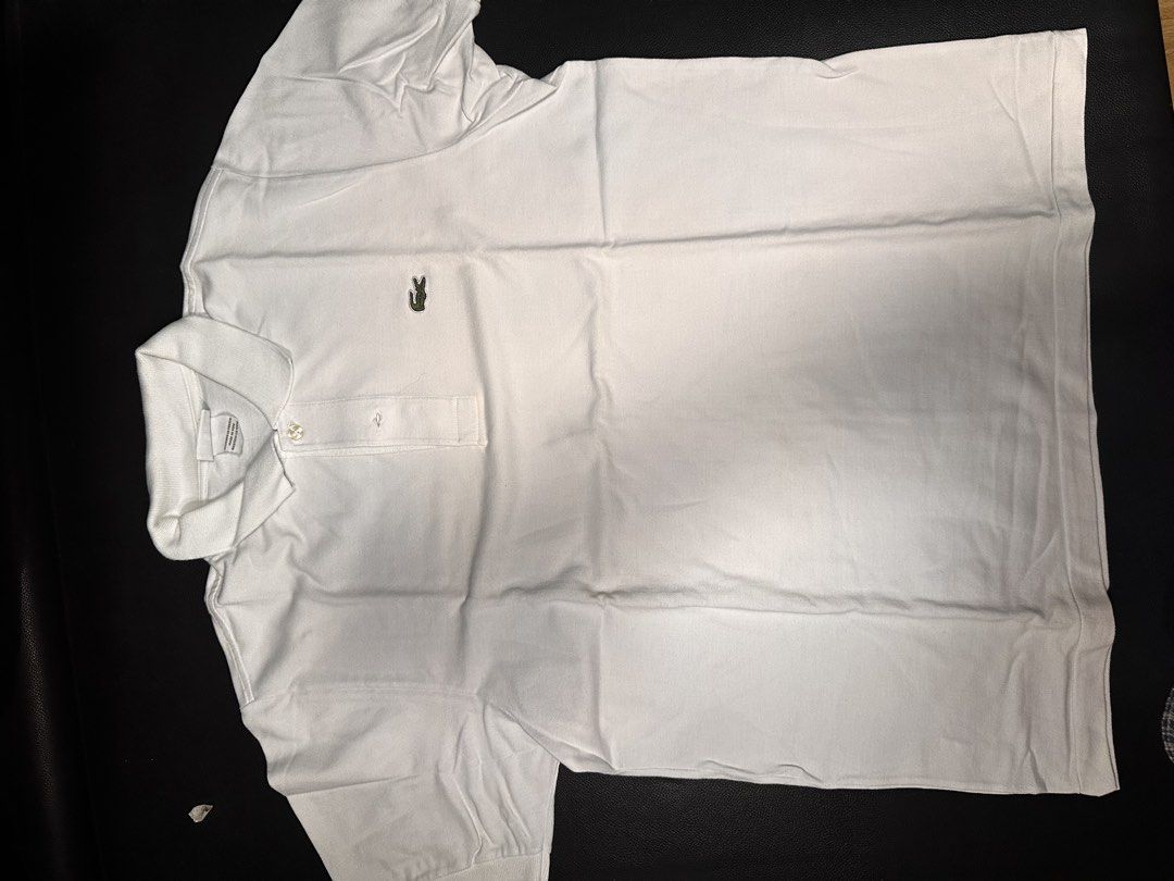 Lacoste White Polo Shirt Size Large (Category: Tshirts & Polo Shirts ) located in Las Pinas. Submitted by boldbear_89ab40 (Listing ID 1470827046, Image 2). Description: - Brand: Lacoste - Color: Clean White - Size: 4 - Material: 100% Cotton Knit - Origin: Designed in France, Made in Peru - Condition: Excellent/Worn with care - Features: Classic short sleeve, button placket, and collar - Styling: Versatile staple, easy to match with jeans or short