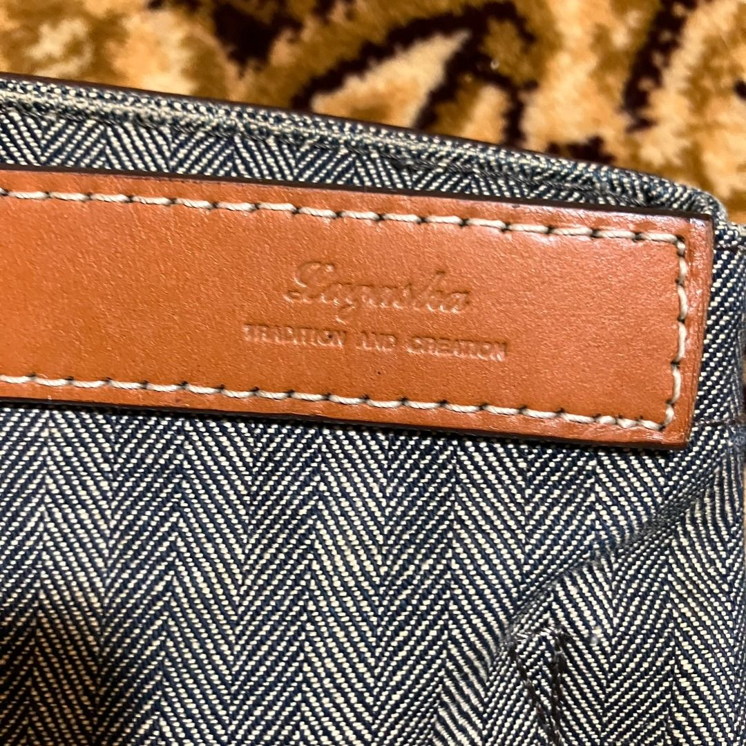 Lagasha Herringbone Twill & Leather Work Tote (Category: Tote Bags) located in Manila. Submitted by nellyfrustrado (Listing ID 1470761947, Image 2). Description: Item Specifics: Brand: Lagasha (Features the classic "Lagasha / TRADITION AND CREATION" stamped leather plaque). Material: Heavy-duty woven herringbone twill fabric (canvas/denim feel) with thick genuine leather straps and trim. Colorway: Indigo/Grey and white herringbone pattern paired 
