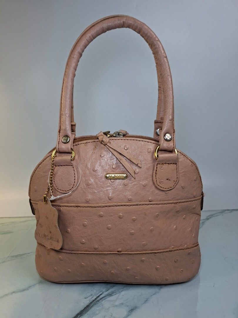 Le Sabbi Pink Ostrich Leather Handbag (Category: Purses & Pouches) located in Pasay City. Submitted by onick_79 (Listing ID 1470917219, Image 1). Description: - Brand/Model: Le Sabbi pink handbag - Dimensions: L23 x H20 x W11 cm - Material/Texture: Stylish ostrich leather texture with elegant gold-tone hardware - Closure & Handles: Secure zip closure with dual top handles - Pockets: Convenient external zippered pocket on the back - Extras: Includ