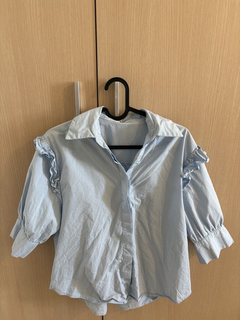 Light blue ruffled sleeve button-up shirt (Category: Blouses) located in Manila. Submitted by clarisseto33619 (Listing ID 1470898417, Image 1). Description: - Color: Light blue - Material: Lightweight, breathable cotton - Design: Classic collar and button-up front - Sleeves: Half sleeves with trendy ruffled shoulders and gathered cuffs - Fit: Standard fit, great for tucking in - Style: Versatile solid color, perfect for everyday casual or smart-c