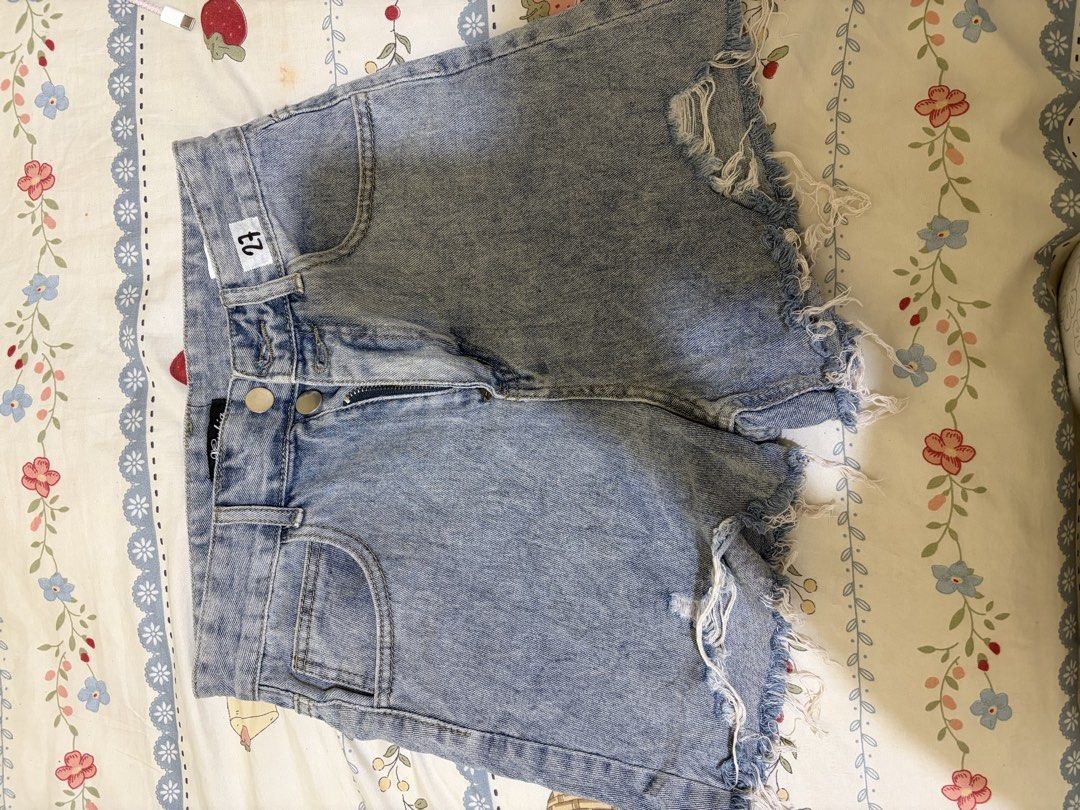 Light wash distressed denim shorts size 27 (Category: Shorts) located in Taguig. Submitted by rarebird_84db64 (Listing ID 1470818173, Image 1). Description: - Size: 27 - Color: Medium blue light wash - Closure: Double button fly - Details: Front distressing with raw frayed hem edges - Pockets: Traditional five-pocket layout.