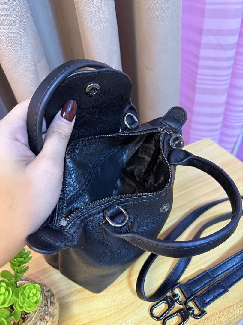 Longchamp Black Leather Handbag with Strap (Category: Luxury Bags & Wallets) located in Davao. Submitted by prince051097 (Listing ID 1470861259, Image 3). Description: - Authentic black leather Longchamp handbag - Versatile design with top handle and detachable shoulder strap - Secure foldover snap flap and zippered main compartment - Stylish patterned fabric interior lining - Compact and practical size for daily essentials.