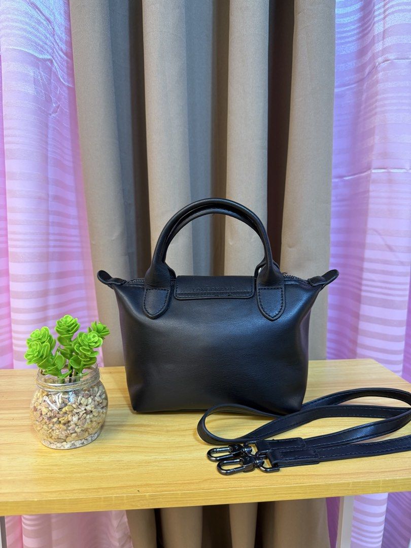 Longchamp Black Leather Handbag with Strap (Category: Luxury Bags & Wallets) located in Davao. Submitted by prince051097 (Listing ID 1470861259, Image 2). Description: - Authentic black leather Longchamp handbag - Versatile design with top handle and detachable shoulder strap - Secure foldover snap flap and zippered main compartment - Stylish patterned fabric interior lining - Compact and practical size for daily essentials.