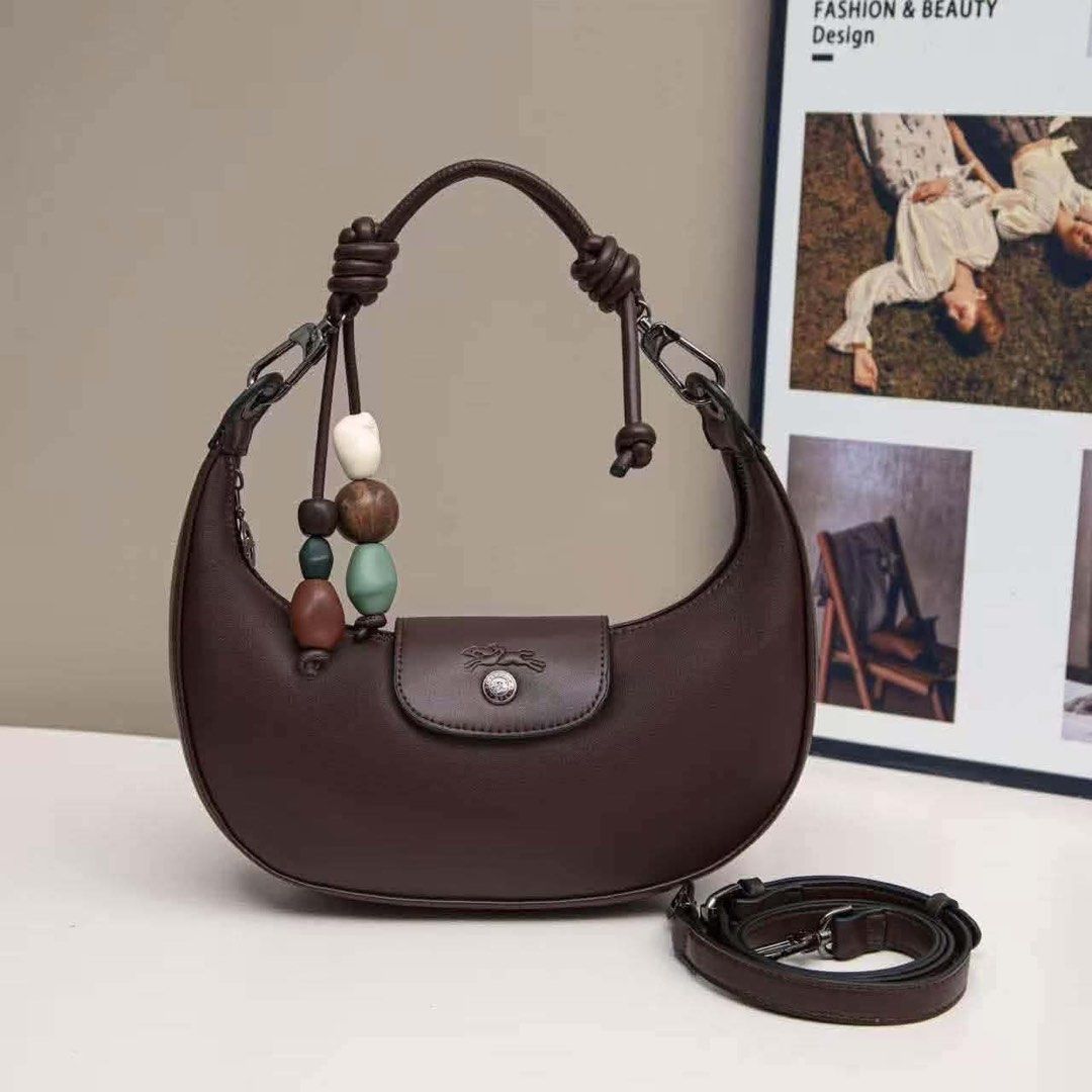 ✨Longchamp Crescent Moon Leather Bag with Bead Charm (Category: Luxury Bags & Wallets) located in Batangas. Submitted by shairapretty (Listing ID 1470888509, Image 3). Description: - PRE-ORDER LONGCHAMP • w Ziplock and dust bag - Style: Crescent-shaped leather handbag - Colors available: Pink, grey, brown, charcoal, and dark blue - Features: Knotted top handle, playful colorful bead charms, flap closure with embossed horse logo and snap button - 