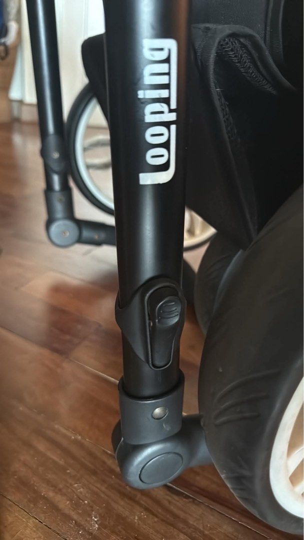 Looping Sydney stroller (Category: Strollers) located in Makati City. Submitted by akimoie (Listing ID 1470852210, Image 2). Description: - Color: Dark grey and black fabric - Wheels: Large wheels with white rims for smooth rides on rough pavement - Suspension: Visible red suspension springs for added comfort - Canopy: Large foldable canopy to block the sun - Storage: Spacious bottom basket for bags and gear - Handlebar: Comfortable foam-wrapped 