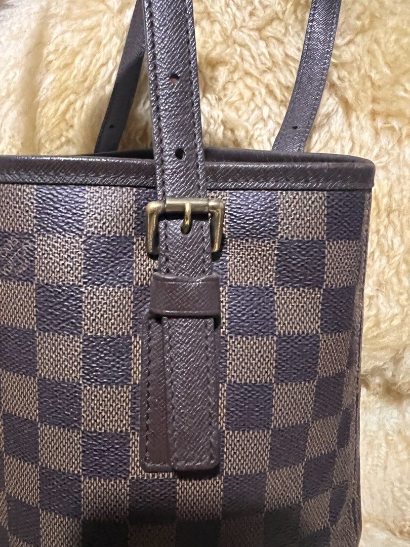 Louis Vuitton Damier Ebene Bucket Bag (Category: Luxury Bags & Wallets) located in Quezon City. Submitted by fly29 (Listing ID 1470856767, Image 3). Description: - Brand: Louis Vuitton - Style: Bucket bag in iconic Damier Ebene canvas - Trim & Straps: Dark brown leather with adjustable shoulder straps - Hardware: Gold-tone hardware with clean condition - Base: Flat oval base equipped with four protective feet - Interior: Vibrant red lining - Cond