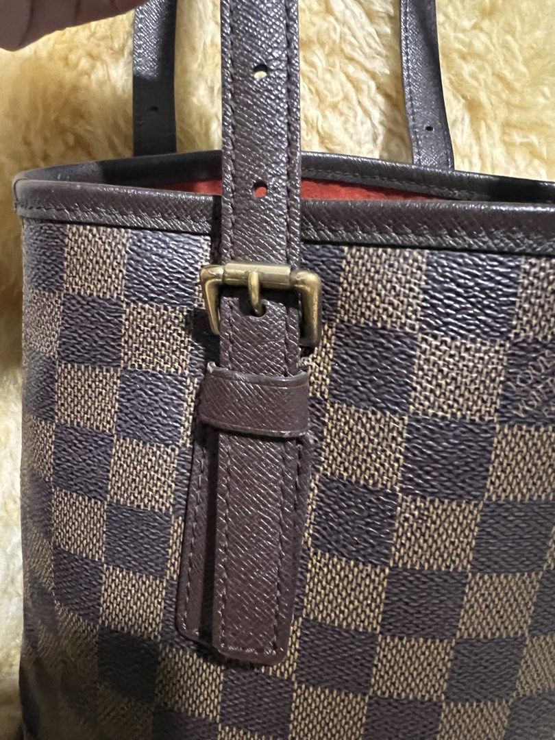Louis Vuitton Damier Ebene Bucket Bag (Category: Luxury Bags & Wallets) located in Quezon City. Submitted by fly29 (Listing ID 1470856767, Image 2). Description: - Brand: Louis Vuitton - Style: Bucket bag in iconic Damier Ebene canvas - Trim & Straps: Dark brown leather with adjustable shoulder straps - Hardware: Gold-tone hardware with clean condition - Base: Flat oval base equipped with four protective feet - Interior: Vibrant red lining - Cond