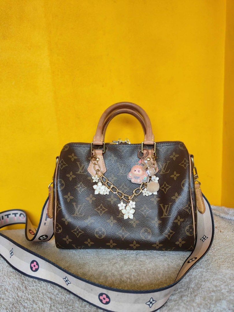 Louis Vuitton Monogram Speedy Handbag with Strap and Charms (Category: Luxury Bags & Wallets) located in Alburquerque. Submitted by wildforest.ea4e9c (Listing ID 1470821775, Image 2). Description: - Authentic Louis Vuitton Monogram Canvas Handbag in classic brown - Premium tan leather handles, side piping, and side tabs - Gleaming gold-tone hardware with dual LV zipper pulls for the top zip closure - Includes a trendy detachable fabric shoulder s