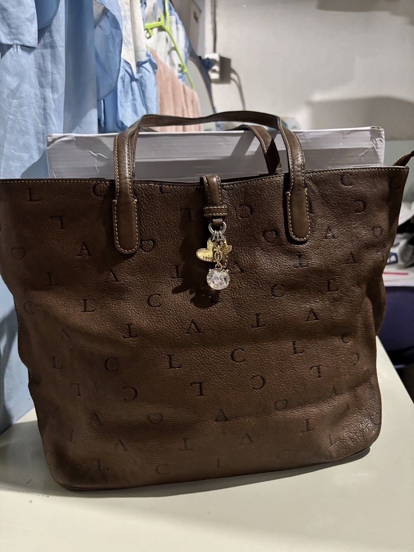 LOVCAT Brown Leather Monogram Tote Bag with Charm (Category: Tote Bags) located in Rizal. Submitted by va_nes_sa_ (Listing ID 1470820140, Image 1). Description: - Brand: LOVCAT RARE ITEM - Material: Premium brown leather with signature letter and heart monogram print - Handles: Double top handles for easy shoulder or hand carry - Hardware: Elegant gold-tone hardware - Special Feature: Gorgeous decorative charm with hearts and a large faceted crys