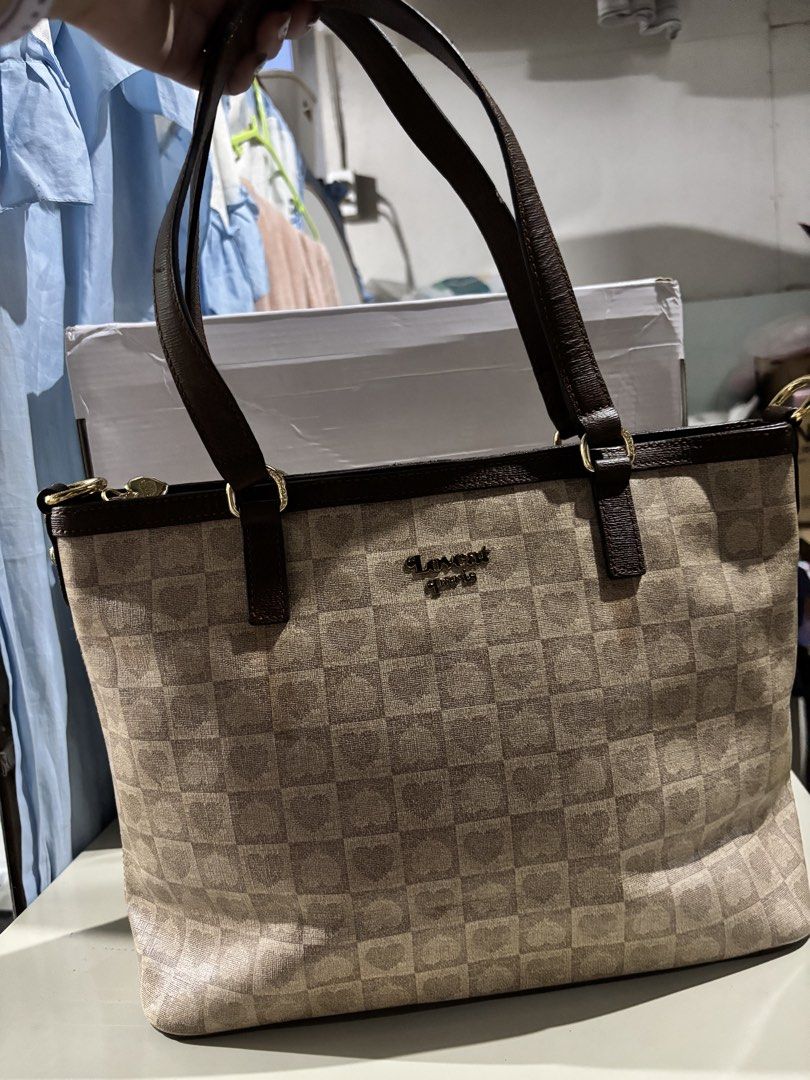 Lovecat Paris Checkered Heart Tote Bag (Category: Tote Bags) located in Rizal. Submitted by va_nes_sa_ (Listing ID 1470820630, Image 2). Description: - Brand: Lovecat Paris - Design: Beige and brown checkered pattern with subtle heart prints inside the squares - Straps & Trim: Dark brown leather-look shoulder straps - Hardware: Gold-tone hardware with a cute heart-shaped stud detail near the handle base - Branding: Metallic gold brand lettering o