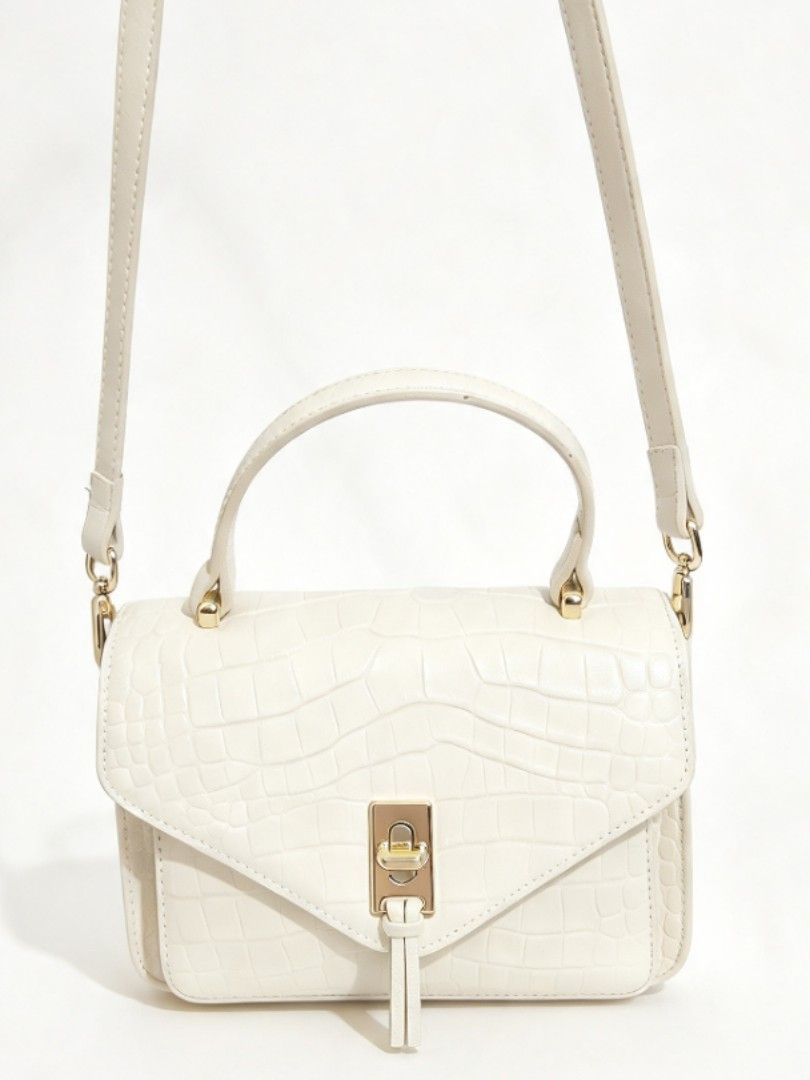 Luxury Unbranded Croc-Embossed Structured Leather Crossbody Bag (Category: Cross-body Bags) located in Naval. Submitted by ziphora.co (Listing ID 1470809870, Image 2). Description: High-quality, thick genuine leather bag in a timeless cream color. Features a beautiful crocodile-embossed finish and sturdy structured shape. Complete with a secure gold-tone turn-lock clasp, elegant top handle, and matching adjustable crossbody strap. Unbranded bouti