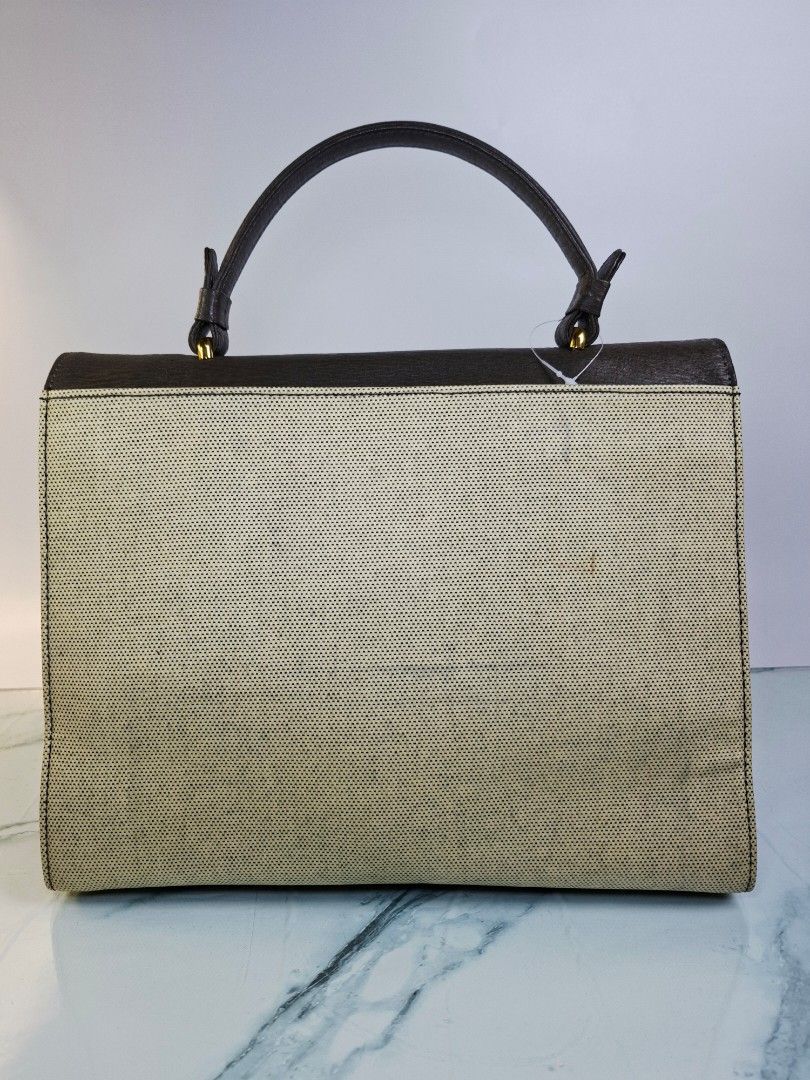 Lydia Two-Tone Leather and Canvas Handbag (Category: Purses & Pouches) located in Pasay City. Submitted by onick_79 (Listing ID 1470918131, Image 2). Description: - Brand: Pelle Borsa -Dimensions: L29 x H23 x W11 cm - Design: Structured shape with a brown textured leather flap and light beige perforated canvas body - Hardware: Silver and gold-tone metal closure engraved with the Lydia brand name - Handle: Single top handle attached with elegant g