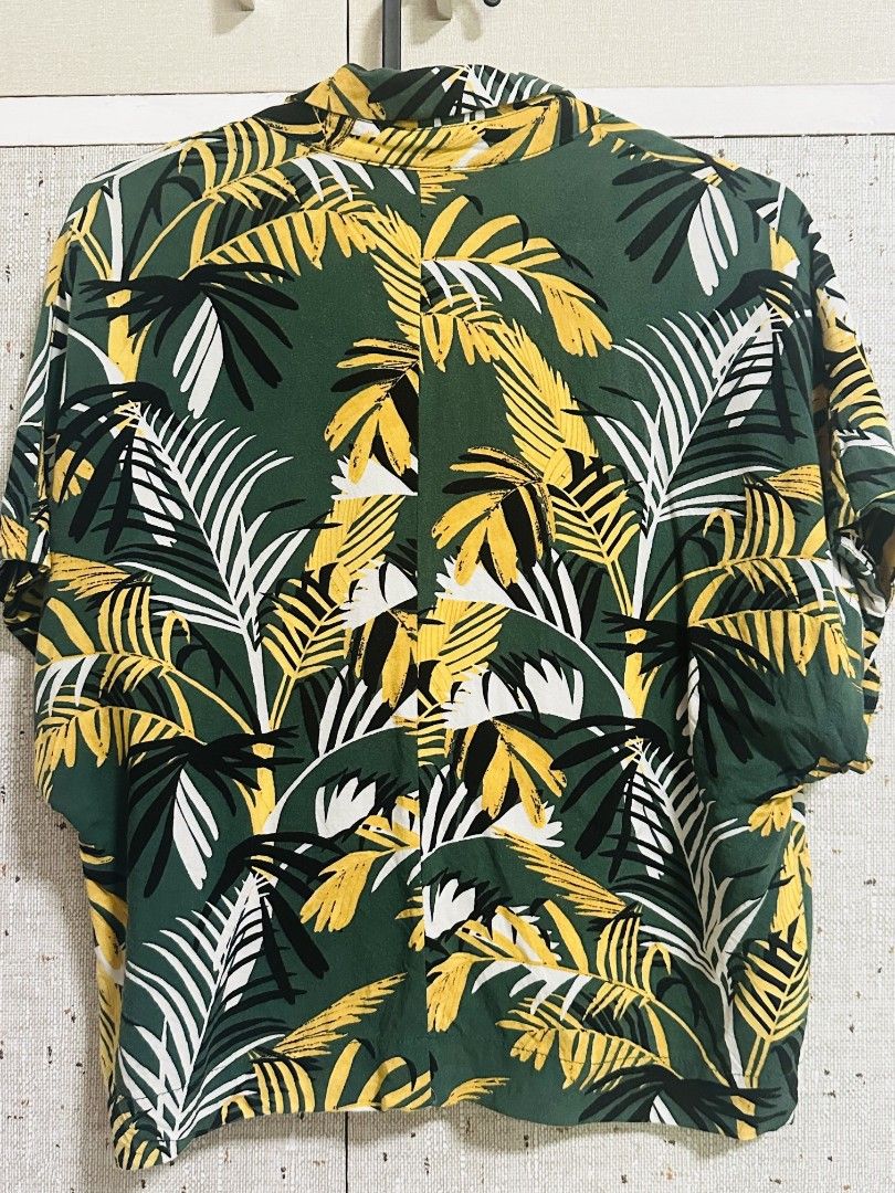 Mango Casual Tropical Leaf Print Button Up Shirt (Category: Shirts) located in Manila. Submitted by thebestre (Listing ID 1470878854, Image 3). Description: - Brand: Mango - Style: Casual button-down with camp collar and tortoiseshell buttons - Print: Bold green, yellow, and white tropical palm leaf pattern - Fit & Size: Relaxed fit, EUR XS / USA 2 - Material: Lightweight fabric, ideal for warm weather and vacations - Condition: Excellent pre-lov