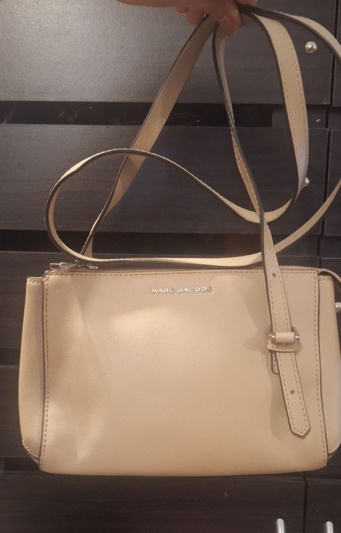 MARC JACOBS Body Bag (Category: Cross-body Bags) located in General Trias. Submitted by aeunice (Listing ID 1470805974, Image 1). Description: Brand: Marc Jacobs In Good Condition. Authentic beige leather Marc Jacobs crossbody bag with silver hardware, adjustable strap, back slip pocket and a burgundy interior with a zip pocket. A chic and versatile bag, perfect for everyday use or casual outings. Meet up / Shipping via Lalamove, JnT, Gogo Expres