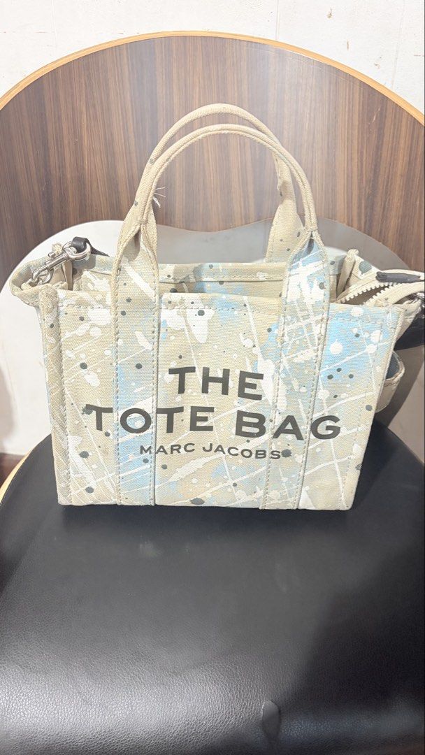 Marc Jacobs The Tote Bag Paint Splatter Canvas (Category: Tote Bags) located in Baguio. Submitted by meiji50 (Listing ID 1470808778, Image 1). Description: - Authentic Marc Jacobs canvas tote bag - Unique blue and white paint splatter design - Dual top handles and adjustable/detachable web strap - Secure top zip closure with silver-tone hardware - Spacious main compartment for all your essentials - Structured material that holds its shape well - 