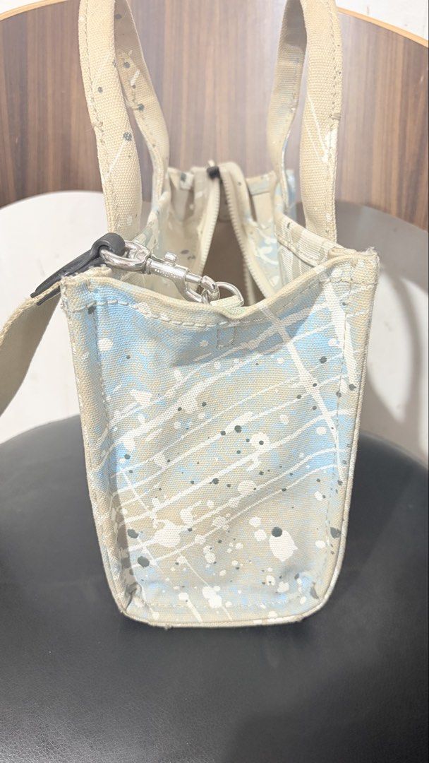 Marc Jacobs The Tote Bag Paint Splatter Canvas (Category: Tote Bags) located in Baguio. Submitted by meiji50 (Listing ID 1470808778, Image 2). Description: - Authentic Marc Jacobs canvas tote bag - Unique blue and white paint splatter design - Dual top handles and adjustable/detachable web strap - Secure top zip closure with silver-tone hardware - Spacious main compartment for all your essentials - Structured material that holds its shape well - 