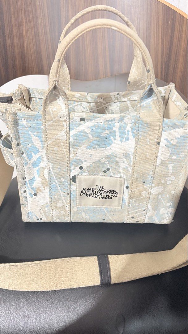 Marc Jacobs The Tote Bag Paint Splatter Canvas (Category: Tote Bags) located in Baguio. Submitted by meiji50 (Listing ID 1470808778, Image 3). Description: - Authentic Marc Jacobs canvas tote bag - Unique blue and white paint splatter design - Dual top handles and adjustable/detachable web strap - Secure top zip closure with silver-tone hardware - Spacious main compartment for all your essentials - Structured material that holds its shape well - 