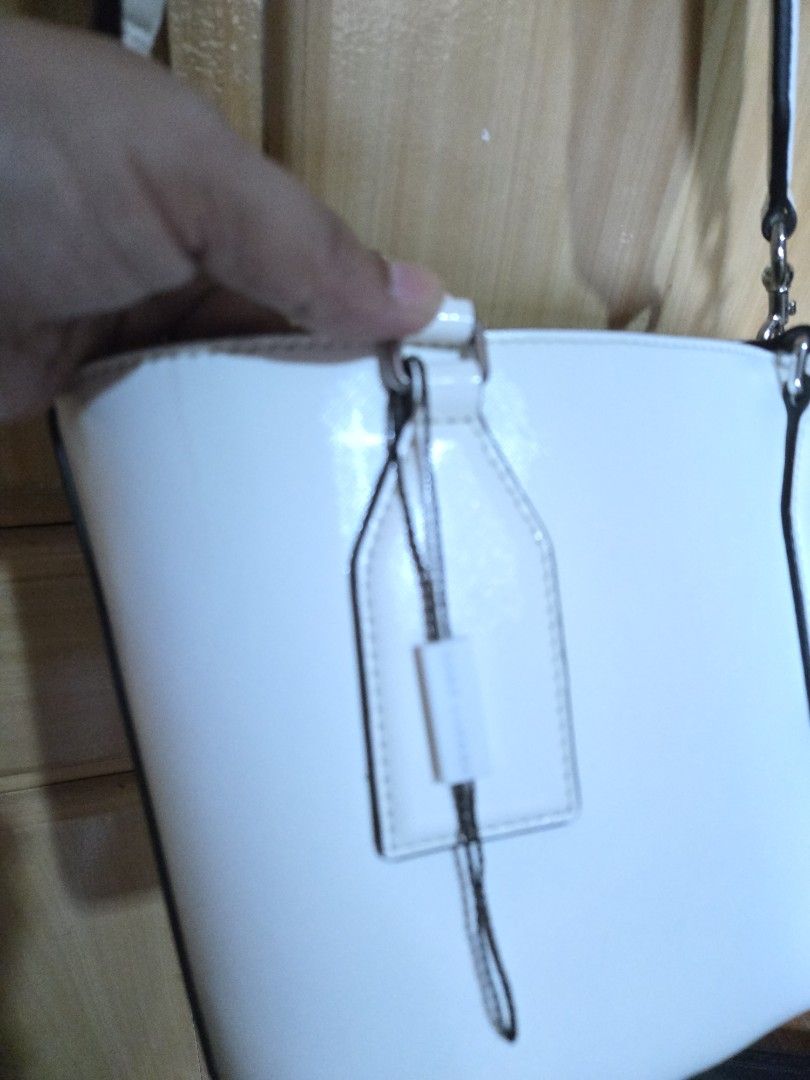Marc Jacobs White Leather Tote Bag (Category: Tote Bags) located in Quezon City. Submitted by mycloset_2016 (Listing ID 1470767982, Image 3). Description: - Authentic Marc Jacobs leather tote in classic white - Sleek silver-tone hardware and bold block lettering logo - Dual top handles plus a trendy, detachable wide woven logo strap - Grey fabric-lined interior with a zipped middle pocket and slip compartments - Structured flat base design to kee