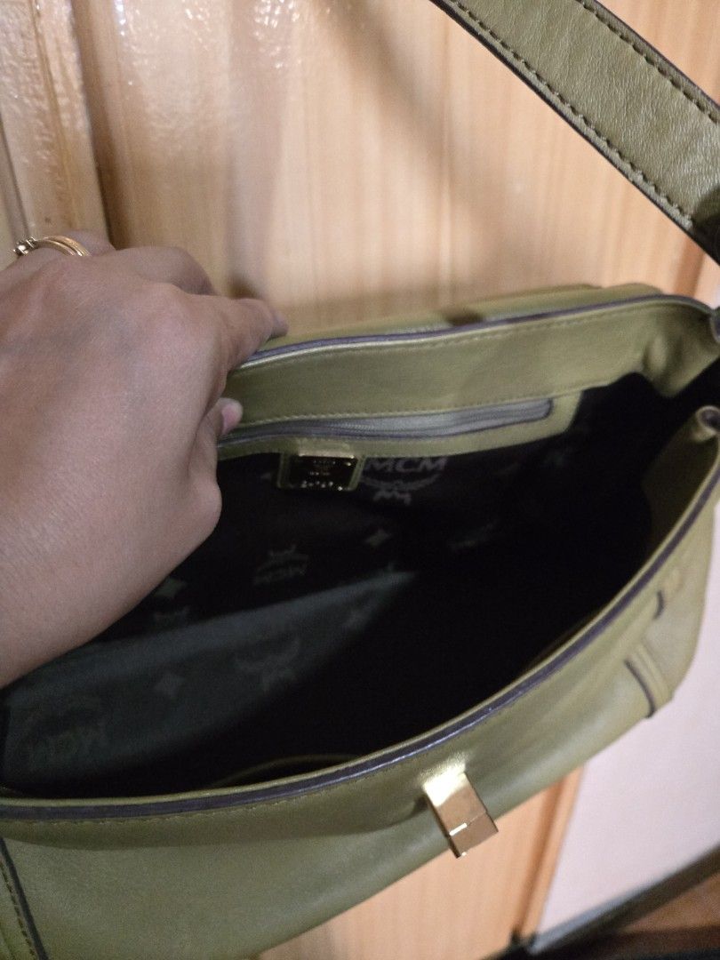 MCM Olive Green Leather Handbag (Category: Luxury Bags & Wallets) located in Quezon City. Submitted by mycloset_2016 (Listing ID 1470767612, Image 2). Description: - Brand: MCM - Color: Olive Green - Material: Premium Leather with Gold-tone hardware - Design: Structured top handle with a detachable shoulder strap - Interior: Monogram-patterned fabric lining with a convenient zippered side pocket - Base: Fitted with metal protective feet - Conditi