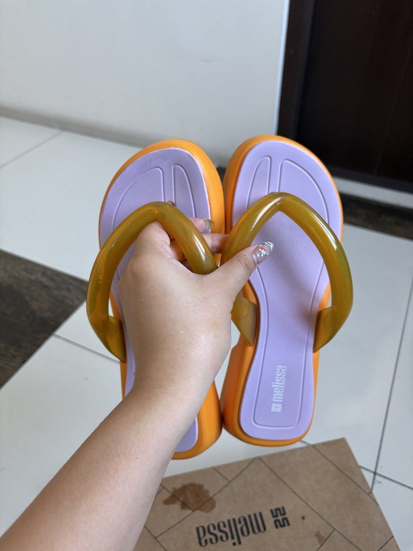Melissa Platform Flip Flops Orange Purple Size 38 (Category: Slippers and slides) located in Manila. Submitted by kylicee (Listing ID 1470898437, Image 3). Description: - Brand: Melissa - Style: Platform flip flops - Color: Vibrant orange, soft purple, and translucent amber strap detail - Size: EUR 38 / US 7 / BRA 36 - Features: Chunky platform sole with unique patterned outsole - Inclusion: Original shoe box included - Condition: Excellent / Rea