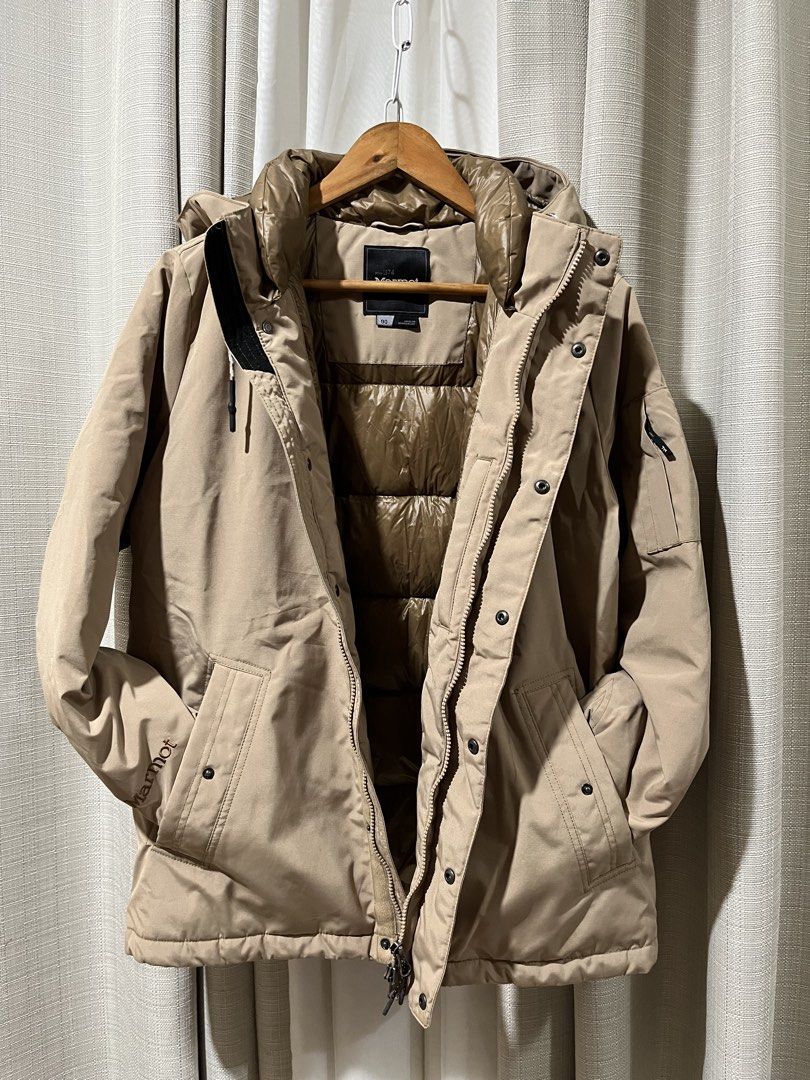 Men Marmot Down Winter Parka Jacket Khaki Beige Size 90 (23” x 27”) (Category: Coats, Jackets and Outerwear) located in Tarlac. Submitted by thriftygoodss (Listing ID 1470928279, Image 3). Description: - Brand: Marmot - Color: Khaki Beige with Glossy Brown Interior - Style: Down Puffer / Hooded Parka - Closure: Front zipper and button closure - Pockets: Multiple functional pockets on front and sleeve - Branding: Embroidered Marmot logo on chest, 