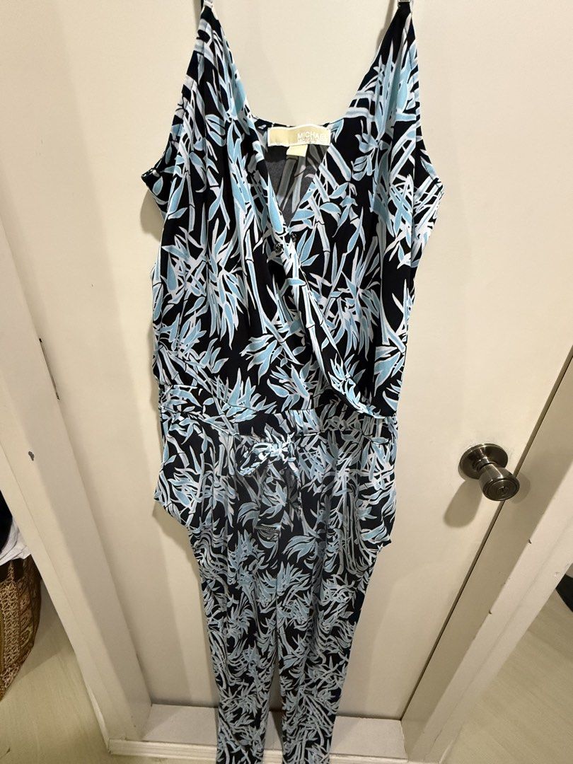 Michael Kors Blue Black Leaf Print Jumpsuit Size M (Category: Jumpsuits) located in Taguig. Submitted by preloved.by.diane (Listing ID 1470874754, Image 2). Description: - Brand: Michael Kors - Size: M - Color/Pattern: Blue, black, and white leaf print - Style: Sleeveless V-neck wrap top with tie belt - Features: Branded metal hardware details on straps - Origin: Made in Vietnam - Condition: Excellent/Worn with care - Perfect for: Casual outings,