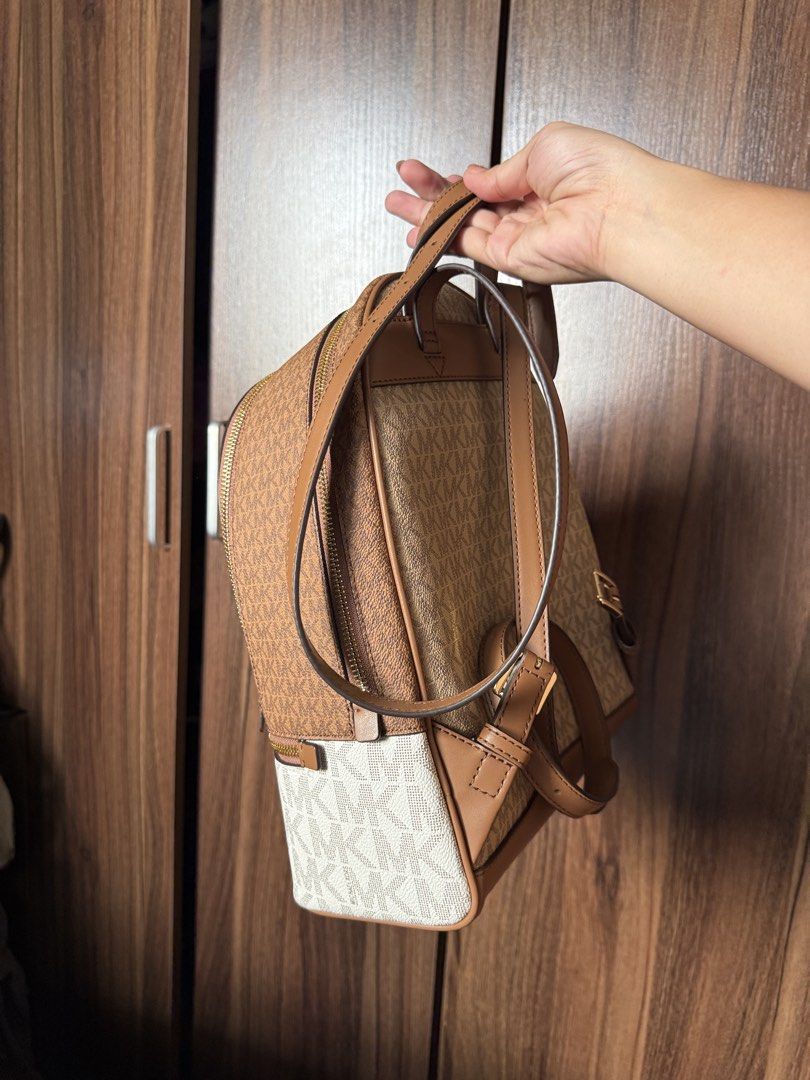 Michael Kors Brown White Monogram Backpack Bag (Category: Backpacks) located in Manila. Submitted by REI.PH (Listing ID 1470755896, Image 3). Description: - Authentic Michael Kors signature monogram backpack - Color/Material: Brown and white coated canvas with tan leather straps - Hardware: Gold-tone hardware with secure zip closure - Interior: Spacious with clean fabric lining - Exterior: Handy front zip pocket for easy access - Condition: Immac