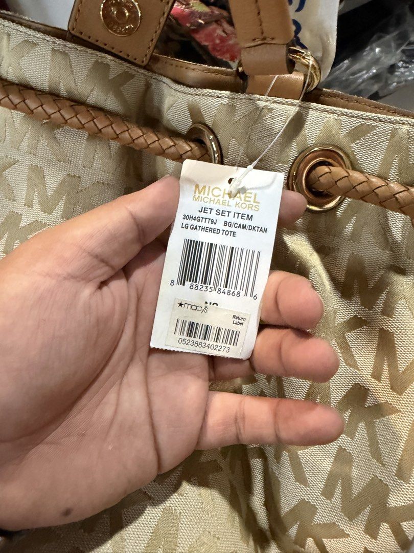 Michael Kors Jet Set LG Gathered Tote (Category: Tote Bags) located in Malabon City. Submitted by LunaAdrienne (Listing ID 1470788569, Image 3). Description: - Brand: Michael Kors - Style: Jet Set Large Gathered Tote - Color/Pattern: Beige and gold MK signature monogram fabric with tan leather trim - Handles: Stylish braided handles with original tissue paper attached - Closure: Drawstring top - Hardware: Gold-tone hardware with signature MK logo