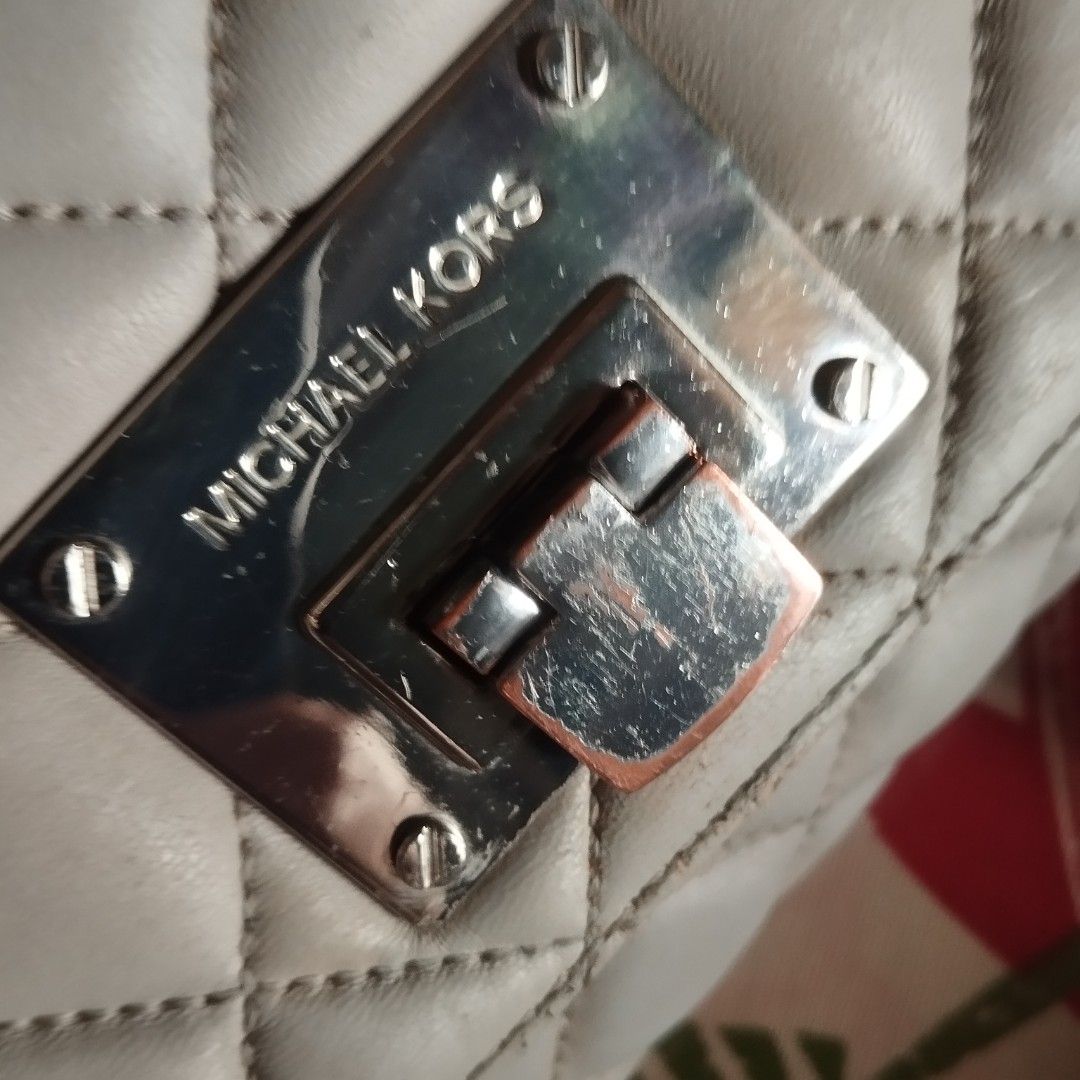 Michael Kors Quilted Leather Shoulder Bag (Category: Cross-body Bags) located in Manila. Submitted by lene48 (Listing ID 1470776101, Image 3). Description: Michael Kors quilted leather shoulder bag in a neutral grey shade. Silver-tone chain strap interwoven with leather. Front metal turn-lock closure with engraved logo. Quilted diamond pattern across the body. Interior lined with MK monogram fabric, including an embossed leather brand patch. Show