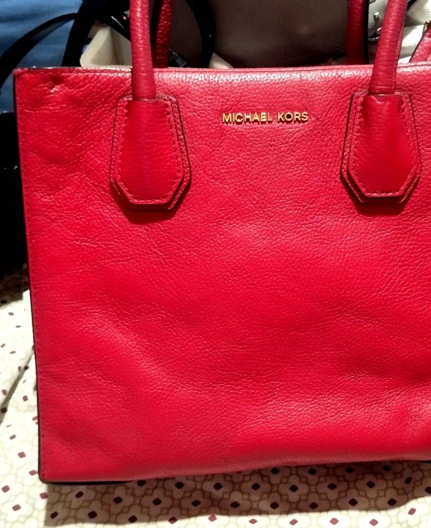 Michael Kors Red Leather Tote Bag (Category: Tote Bags) located in Manila. Submitted by lene48 (Listing ID 1470853006, Image 1). Description: - Brand: Michael Kors - Material: Bright red pebbled leather with gold-toned hardware - Straps: Double top handles and an adjustable, detachable shoulder strap - Interior: Fabric-lined with multiple compartments - Exterior: Four metal protective feet at the bottom - Condition: Good pre-loved condition, with