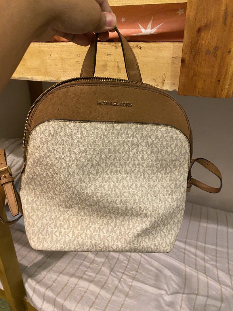 Michael Kors Signature Brown Cream Monogram Backpack (Category: Backpacks) located in Bauan. Submitted by oneiasan (Listing ID 1470856892, Image 1). Description: - Authentic Michael Kors backpack in brown and cream MK monogram - Features stylish gold-tone hardware and front pocket lettering - Secure zip-around closure with spacious fabric-lined interior and pockets - Designed with a top handle and comfortable adjustable shoulder straps - Versatil