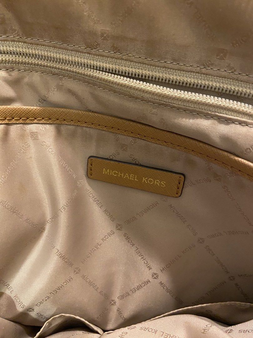 Michael Kors Signature Brown Cream Monogram Backpack (Category: Backpacks) located in Bauan. Submitted by oneiasan (Listing ID 1470856892, Image 3). Description: - Authentic Michael Kors backpack in brown and cream MK monogram - Features stylish gold-tone hardware and front pocket lettering - Secure zip-around closure with spacious fabric-lined interior and pockets - Designed with a top handle and comfortable adjustable shoulder straps - Versatil
