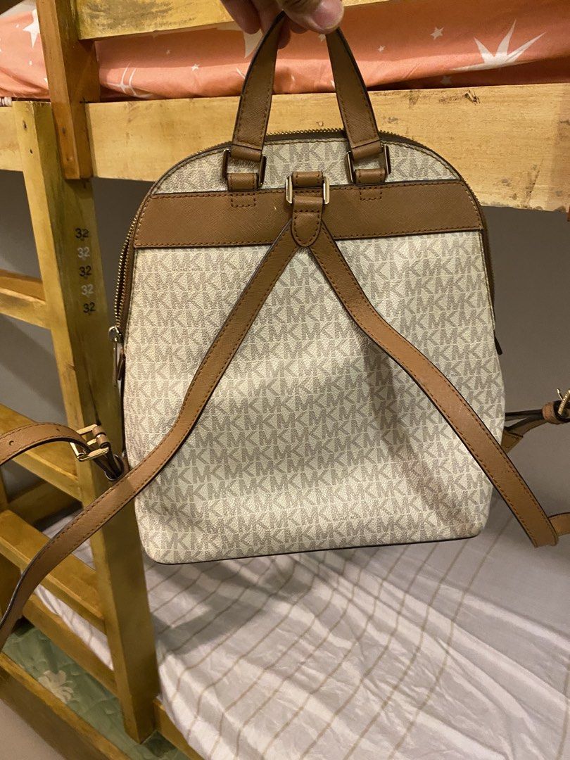 Michael Kors Signature Brown Cream Monogram Backpack (Category: Backpacks) located in Bauan. Submitted by oneiasan (Listing ID 1470856892, Image 2). Description: - Authentic Michael Kors backpack in brown and cream MK monogram - Features stylish gold-tone hardware and front pocket lettering - Secure zip-around closure with spacious fabric-lined interior and pockets - Designed with a top handle and comfortable adjustable shoulder straps - Versatil