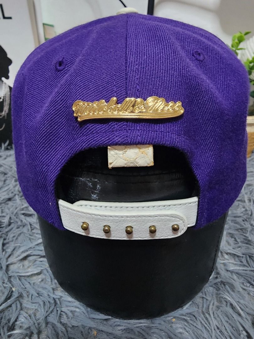 Mitchell & Ness Hardwood Classics Purple White Snapback Hat (Category: Caps & Hats) located in Caloocan City. Submitted by mastap32 (Listing ID 1470850729, Image 2). Description: - Brand: Mitchell & Ness Hardwood Classics - Material: Purple wool crown with white textured faux leather brim and strap - Details: Gold metal script logo on back, NBA Hardwood Classics side patch, and Philadelphia inner taping - Closure: Adjustable snapback with brass-c