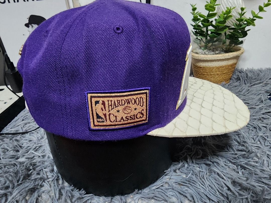 Mitchell & Ness Hardwood Classics Purple White Snapback Hat (Category: Caps & Hats) located in Caloocan City. Submitted by mastap32 (Listing ID 1470850729, Image 3). Description: - Brand: Mitchell & Ness Hardwood Classics - Material: Purple wool crown with white textured faux leather brim and strap - Details: Gold metal script logo on back, NBA Hardwood Classics side patch, and Philadelphia inner taping - Closure: Adjustable snapback with brass-c