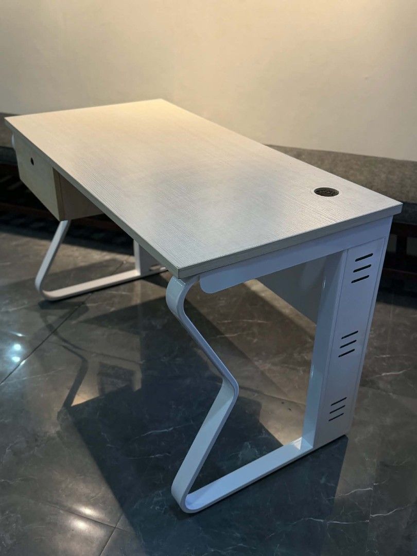 Modern study desk with white metal frame and drawer (Category: Office Furniture & Fixtures) located in Quezon City. Submitted by kcofficefurnitures (Listing ID 1470828441, Image 3). Description: OFFICE TABLE WITH DRAWER – LIGHT WOOD FINISH Upgrade your workspace with this stylish and functional office table, perfect for offices, home offices, and study areas. Product Details: Design: Modern minimalist Color: Light wood finish with white metal leg