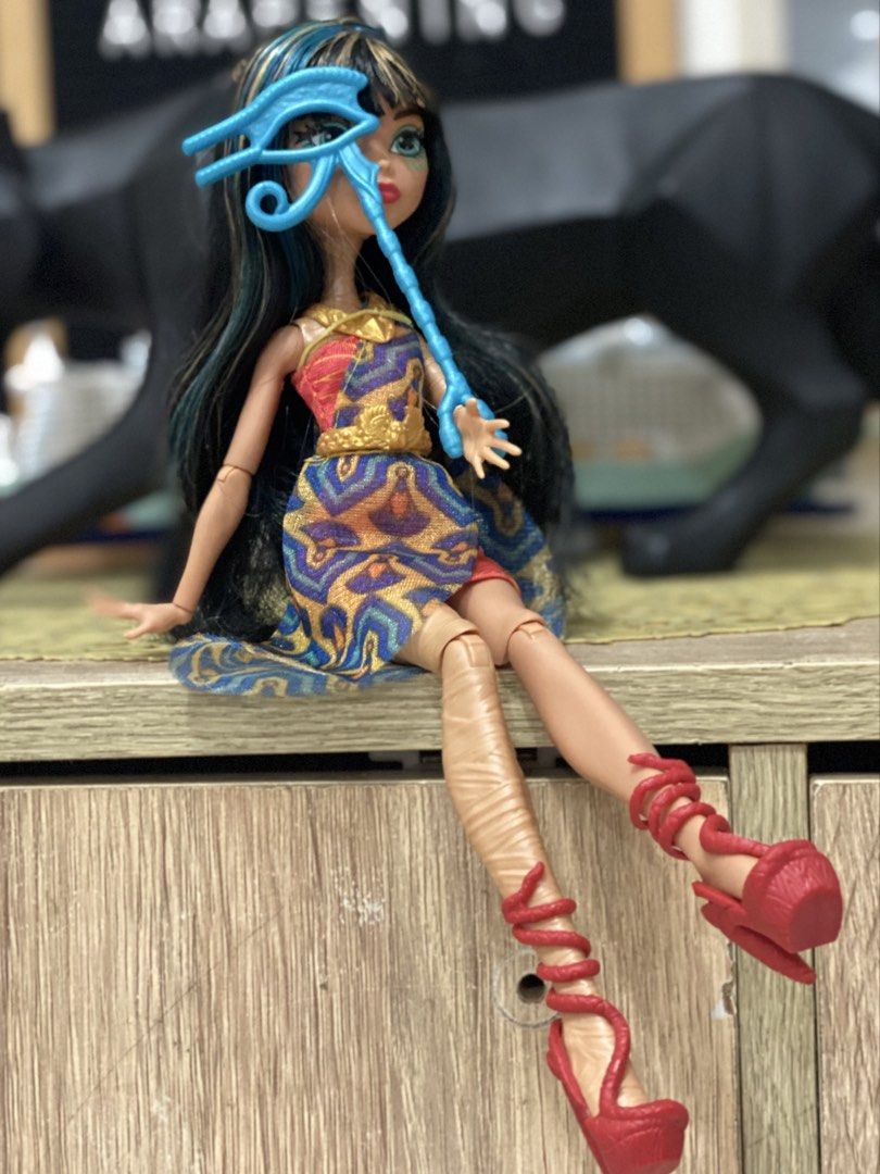 Monster High Cleo De Nile Doll with Accessories (Category: Kids Toys) located in Manila. Submitted by deniseeverafter (Listing ID 1470774284, Image 1). Description: -Complete -Clean -Features her signature long black and blue-streaked hair, patterned gold-detail dress, red wrap heels, and blue eye-symbol staff. Clean and ready to display..