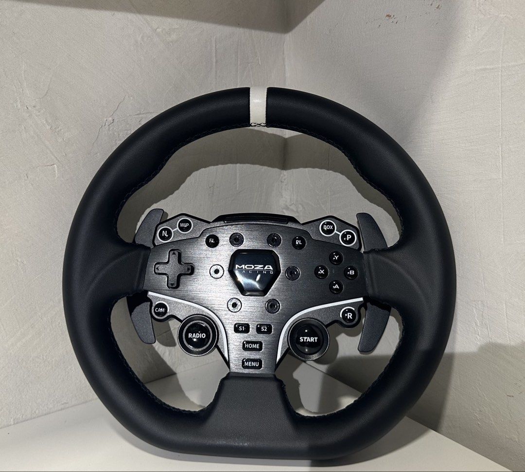 Moza Racing ES Steering Wheel (Category: Controllers) located in Las Pinas. Submitted by retrosanity (Listing ID 1470846463, Image 1). Description: With freebies: - Authentic Moza Racing ES steering wheel for sim racing setups - Premium leather grip with a visible center stripe indicator - Built-in responsive paddle shifters, d-pad, face buttons, and rotary dial - Sleek clean metal faceplate with durable black buttons - Equipped with a quick-rele