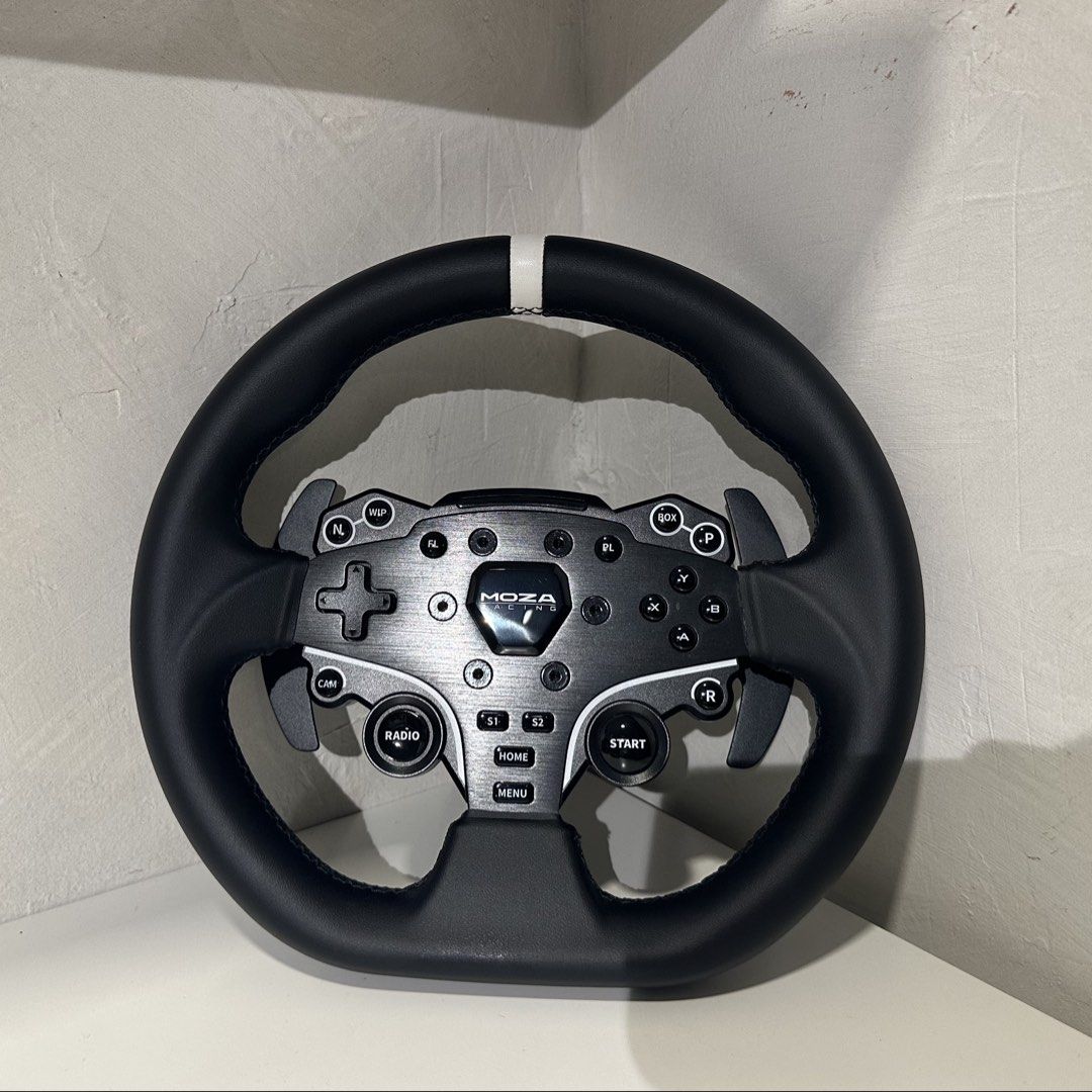 Moza Racing ES Steering Wheel (Category: Controllers) located in Las Pinas. Submitted by retrosanity (Listing ID 1470846463, Image 2). Description: With freebies: - Authentic Moza Racing ES steering wheel for sim racing setups - Premium leather grip with a visible center stripe indicator - Built-in responsive paddle shifters, d-pad, face buttons, and rotary dial - Sleek clean metal faceplate with durable black buttons - Equipped with a quick-rele
