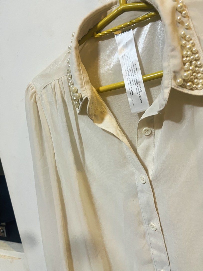 MURUA Cream Pearl Collar Long Sleeve Button Down Blouse (Category: Blouses) located in Bulacan. Submitted by grazcloset (Listing ID 1470838086, Image 2). Description: - Brand: MURUA - Color: Cream - Style: Long-sleeve button-down blouse with a classic collar - Detail: Elegant pearl embellishments along the collar and gathered shoulder details - Fabric: Lightweight with a subtle sheen - Versatility: Great for smart-casual looks or dressing up.