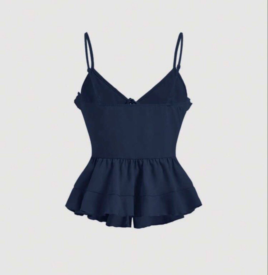 Navy Blue Ruffled Peplum Cami Top (Category: Sleeveless) located in Manila. Submitted by clothesofitiew (Listing ID 1470775507, Image 2). Description: - Color: Navy blue - Design: Cute ruffles along neckline, waist, and hem with multiple front tie strings - Style: Peplum flare with thin spaghetti straps and clean ruffled back tier - Versatile piece great for casual days or nights out.