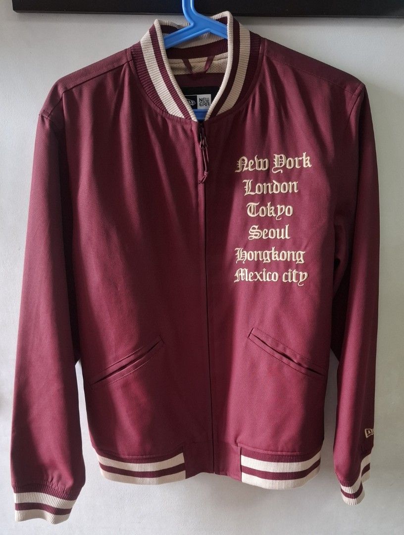 New Era Reversible Bomber Jacket Burgundy Beige Medium (Category: Coats, Jackets and Outerwear) located in Taguig. Submitted by atticusmerch (Listing ID 1470780153, Image 1). Description: Reversible bomber jacket from New Era. One side maroon with city names and globe graphic on back. Other side beige mesh with maroon center stripe. Zip front, striped ribbed collar, cuffs, and hem. Size medium based on tag. Clean condition overall, minimal wear..