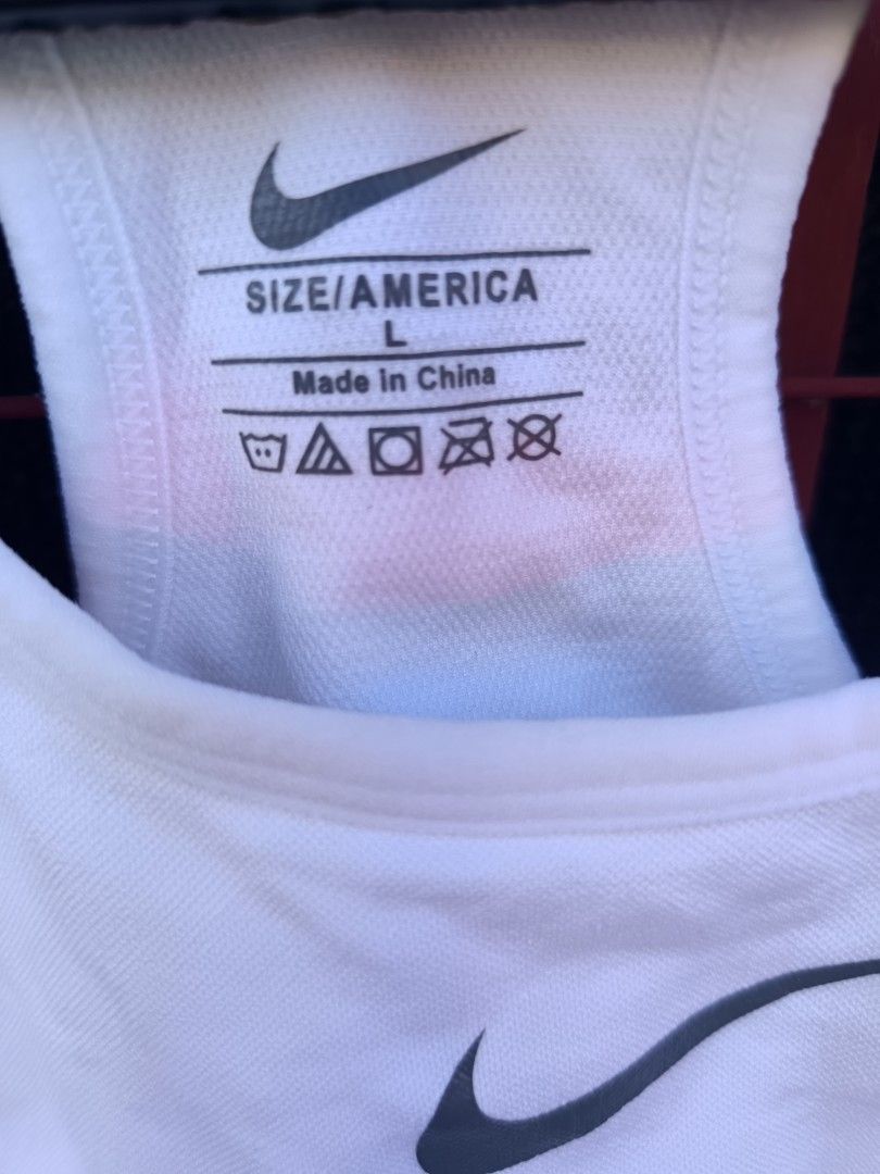Nike (Category: Activewear) located in Cavite. Submitted by vin2za06 (Listing ID 1470755008, Image 3). Description: white Nike women's sports bra with a racerback design and a black Nike Swoosh logo on the front..