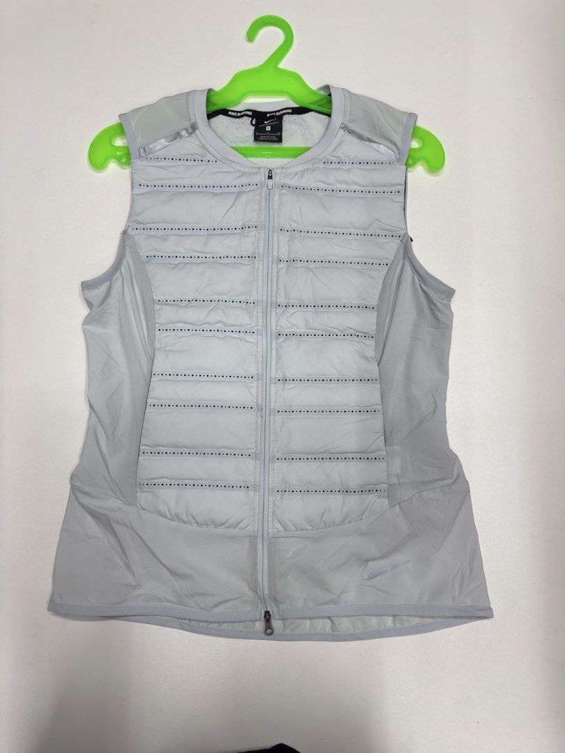 Nike Aeroloft Running Vest Size S (Category: Activewear) located in Bustos. Submitted by thenlnclot60500 (Listing ID 1470812265, Image 1). Description: - Brand: Nike Aeroloft - Item: Running Vest - Color: Light Grey and Black - Size: S - Material: 90% White Goose Down fill for lightweight warmth - Ventilation: Laser-perforated holes on upper back and chest for breathability - Design: Zip-up front with high collar - Safety: Reflective details for 