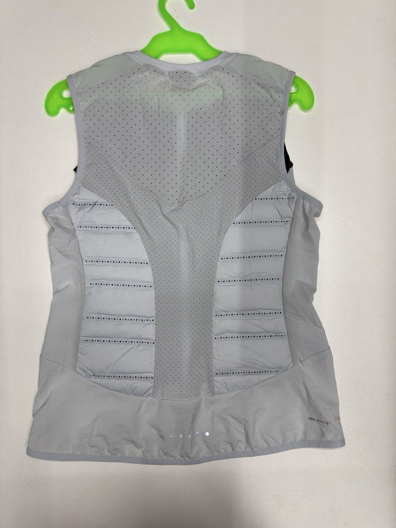 Nike Aeroloft Running Vest Size S (Category: Activewear) located in Bustos. Submitted by thenlnclot60500 (Listing ID 1470812265, Image 2). Description: - Brand: Nike Aeroloft - Item: Running Vest - Color: Light Grey and Black - Size: S - Material: 90% White Goose Down fill for lightweight warmth - Ventilation: Laser-perforated holes on upper back and chest for breathability - Design: Zip-up front with high collar - Safety: Reflective details for 