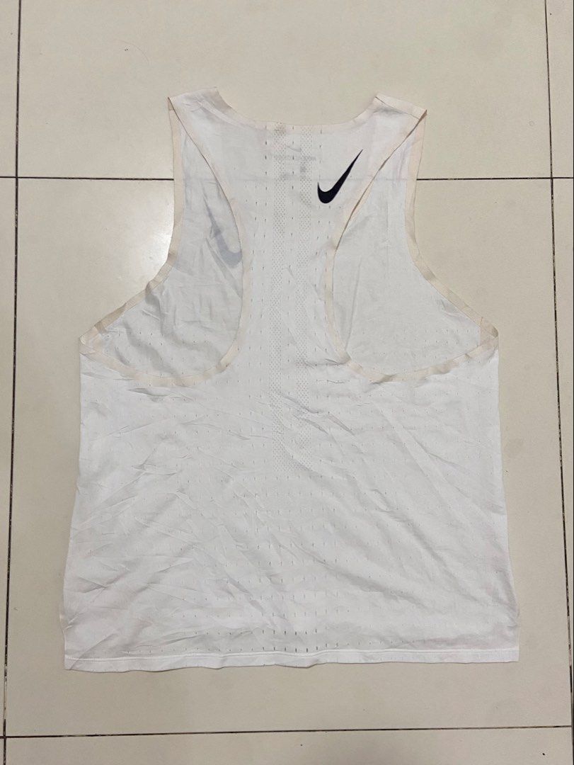 Nike AeroSwift Running Singlet White Men's Size L (Category: Activewear) located in Calumpit. Submitted by Ketchi (Listing ID 1470897790, Image 2). Description: - Brand: Nike AeroSwift - Color: White with black Swoosh logos on chest and back - Size: Large - Material: Breathable mesh fabric for optimal performance - Details: Printed neck label, sleeveless athletic top - Origin: Made in Cambodia Dimes: 25x18.5.