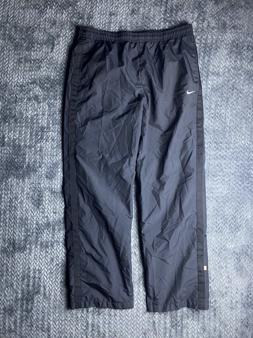 Nike Black Windbreaker Pants Size XL (Category: Joggers) located in Olongapo. Submitted by WAVYT (Listing ID 1470893621, Image 1). Description: - Brand: Nike - Item: Windbreaker Pants - Color: Black with white accents - Size: XL - Details: Embroidered white swoosh on left thigh, stylish side stripes down both legs - Comfort & Fit: Elastic waistband with adjustable white drawstring and breathable mesh lining - Storage: Functional back pocket with 